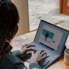 a woman sitting at a table using a laptop computer