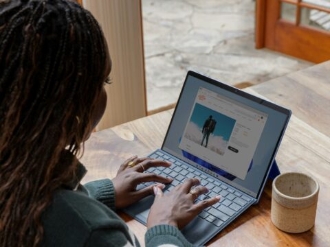 a woman sitting at a table using a laptop computer