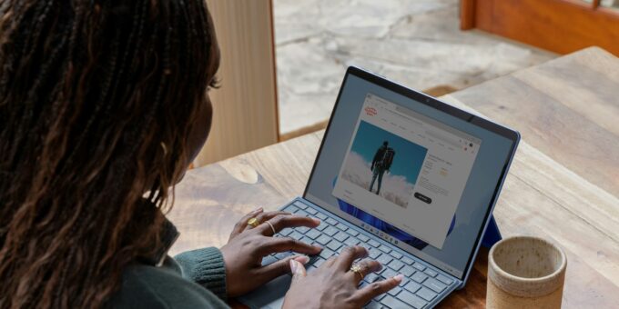 a woman sitting at a table using a laptop computer