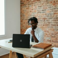 a man sitting at a table in front of a laptop