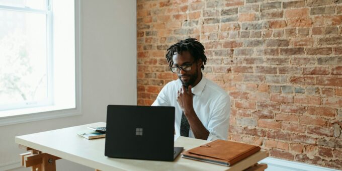 a man sitting at a table in front of a laptop