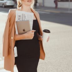 a woman in a black dress holding a cup of coffee