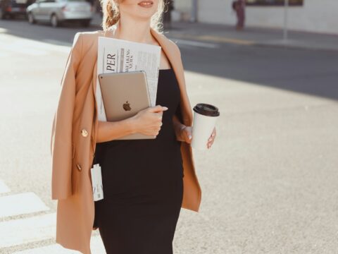 a woman in a black dress holding a cup of coffee