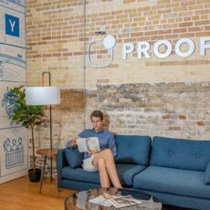 man sitting on blue sofa while reading book