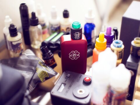 red box mod vape beside e-juice bottles